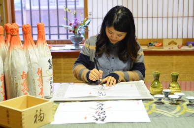 Demonstrating the calligraphy required for creating sake bottle labels